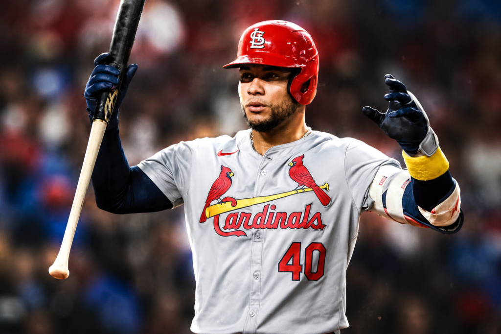 Willson Contreras of the St. Louis Cardinals raises his bat during a game in a dramatic, high-resolution sports portrait.